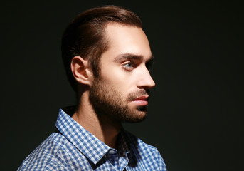 Young handsome man on black background