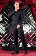 Handsome young man in black suit on red carpet