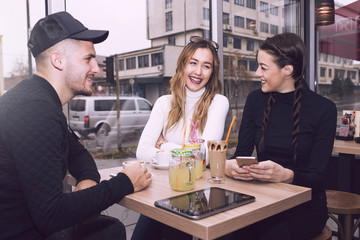  Young man and two women sitting  in the cafe shop
