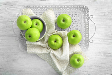Tray with fresh green apples on wooden background