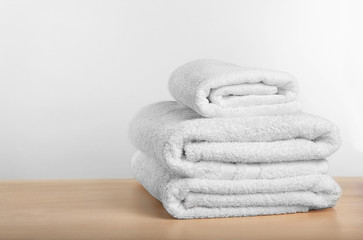 Fototapeta na wymiar Clean towels on table against light background