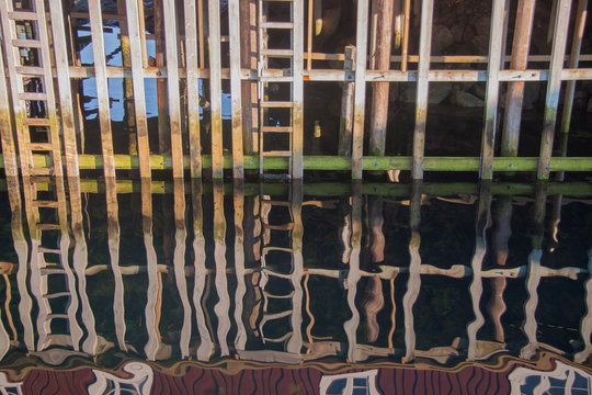 Abstract impression &ndash; reflective closeup of wooden fishermen houses built over the sea at the Lofoten islands, Norway