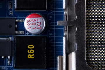 Fragment of an electronic circuit board with a variety of electronic components close-up.