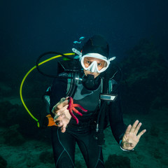 The diver holds the starfish