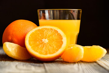 Oranges and orange juice on a wooden background