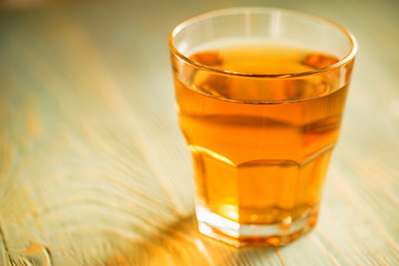 Glass of fresh apple juice or cider on wood table