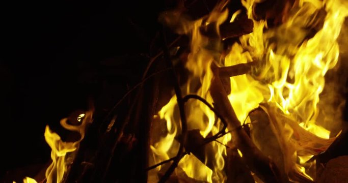 Bonfire burns intensely as it reaches news paper - slow motion