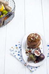 pancakes with jam and figs on a white plate