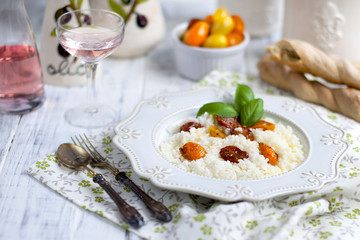 riszoto with cherry tomatoes and pink wine, homemade bread on white background