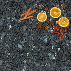Orange slices, cinnamon, goji berries, pine cones, anise on emerald pearl granite worktop