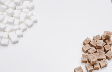 Cubes of white and brown sugar on the white background