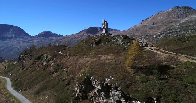 Stone statue, Cinema 4k aerial view over a eagle statue monument, on the top of simplon pass, on a sunny autumn evening, in Valais, Switzerland