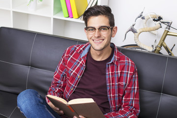 young adult Reading the book in the home or apartment sofa