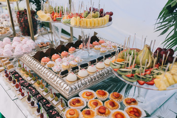 Beautiful wedding sweet buffet with decor and green.