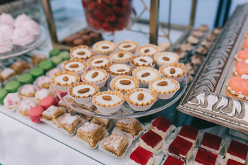 Beautiful wedding sweet buffet with decor and green.