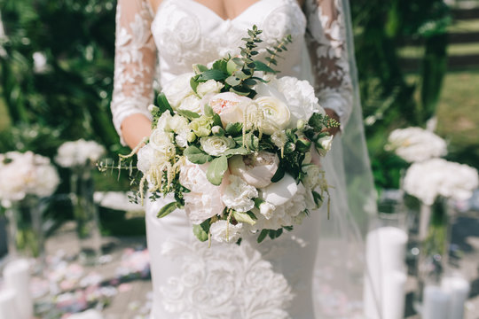 Bride holding beautiful white and green bouquet on the wedding.