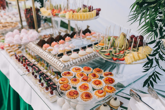 Beautiful wedding sweet buffet with decor and green.