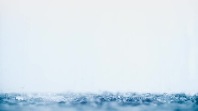 Water flow with lot of droplets and splashes on clean white background in shower
