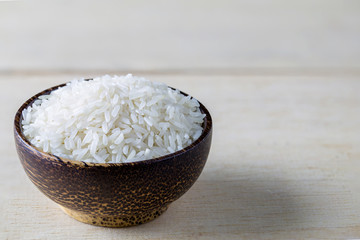 raw white rice in a bowl on wood table