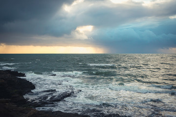 Dramatic sky over the sea, rain and sun, storm, waves in Ireland, Wexford