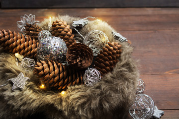 Winter holiday lights with pine cones and ornaments in fur