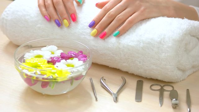 Female hands receiving spa treatment. Female hands with fresh summer manicure on white towel afte spa. Skin care and spa therapy.