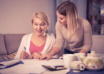 Fototapeta premium Daughter helps mother to lead home accounting