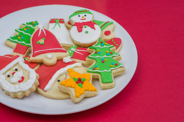 Biscoitos de natal em prato branco com fundo vermelho