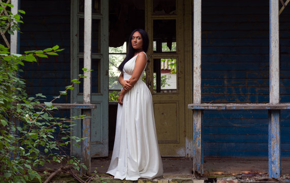 Portrait of  young black woman  against  background of an old abandoned house
