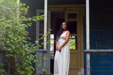 Portrait of  young black woman  against  background of an old abandoned house