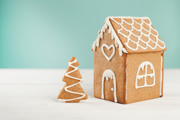 Gingerbread house and gingerbread tree on a light background, copy space
