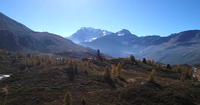 Stone statue, Cinema 4k aerial view over a eagle statue monument, revealing the mountain village on the top of simplon pass, on a sunny autumn evening, in Valais, Switzerland