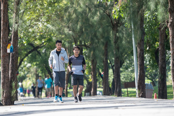 Two young fitness man running at morning in the garden, park