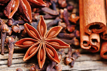 Anise star with cloves and cinnamon sticks on rustic table