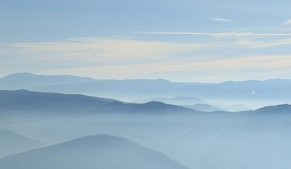 Mountain layer in morning sun ray and winter fog