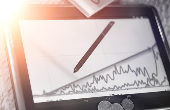 The graph of income growth. Electronic tablet with a graph of gr