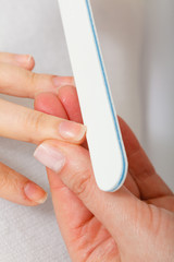 Preparing nails before manicure, beautician file nails