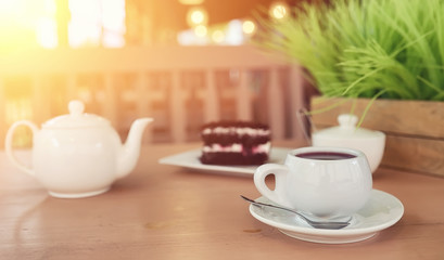 Kettle with a drink and dessert in a street cafe. Tea in the ket