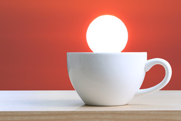 White cup of coffee is placed on a wooden table.