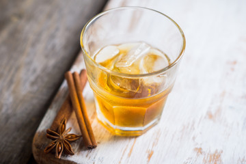 Glass with whiskey on the rustic wooden background. Selective focus. Shallow depth of field.