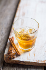 Glass with whiskey on the rustic wooden background. Selective focus. Shallow depth of field.