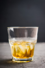 Glass with whiskey on the rustic wooden background. Selective focus. Shallow depth of field.