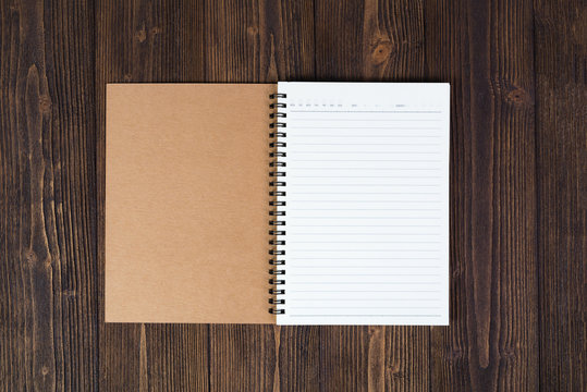 Notebook or empty white paper on wood table top view with copy space,