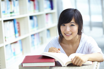 pretty Asian college student in library