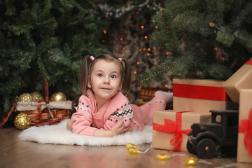 Little girl in new year's Christmas atmosphere. The girl is happ