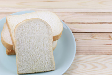 Sliced bread Stacked in green dish on wooden floor.