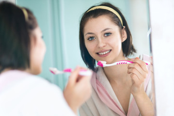 woman in the bathroom brushes teeth