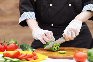 The cook cuts fresh farm vegetables