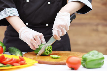 The cook cuts fresh farm vegetables