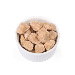Natural sugar cubes in bowl on white background